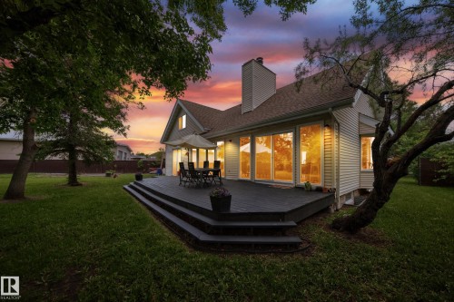 Expansive multi-level wood-finish deck with integrated steps, large sliding glass doors, and a neutral-toned exterior siding - 8224 186 Street Nw, Edmonton, AB 