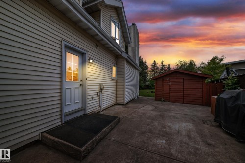 Siding exterior with a ground-level access door and paved patio - 8224 186 Street Nw, Edmonton, AB 