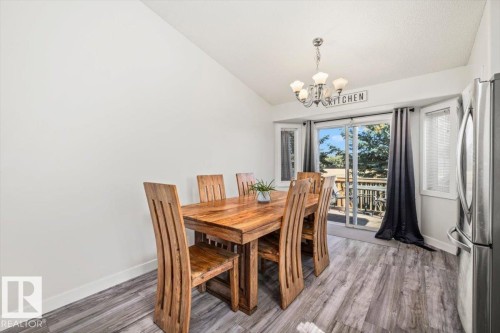 Vaulted ceiling, wood-finish flooring, sliding glass door, bay window, and a five-light chandelier - 40 Hampton Place, Stony Plain, AB 