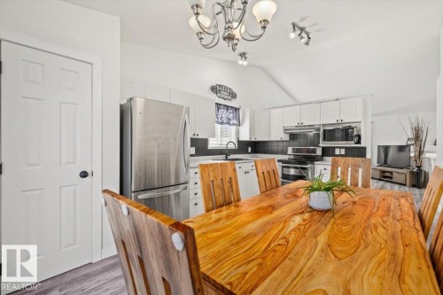 Vaulted ceiling with an elegant chandelier and track lighting - 40 Hampton Place, Stony Plain, AB 