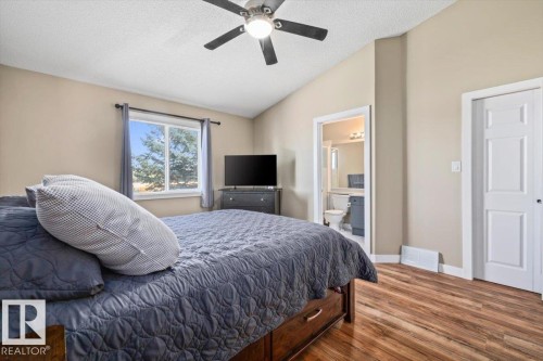Vaulted ceiling with ceiling fan, wood-finish flooring, and white trim throughout - 40 Hampton Place, Stony Plain, AB 