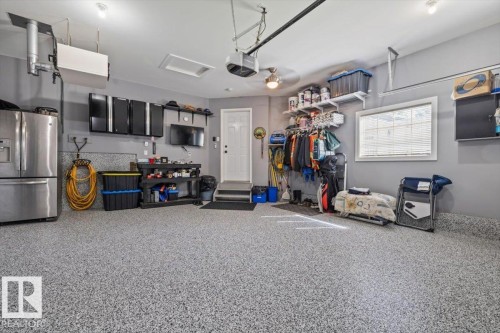 Epoxy-coated flooring, built-in cabinetry, ceiling fan, and window with blinds - 40 Hampton Place, Stony Plain, AB 