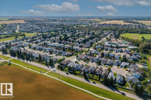 Residential neighborhood with mature trees, green spaces, and a nearby school building - 40 Hampton Place, Stony Plain, AB 
