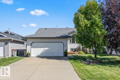 Welcoming two-car garage with a paneled overhead door opens to a concrete driveway - 40 Hampton Place, Stony Plain, AB 