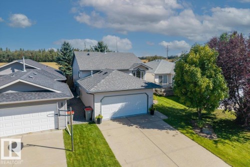 Two-story residence featuring a shingled roof, attached garage, and a concrete driveway - 40 Hampton Place, Stony Plain, AB 
