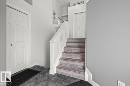 Staircase featuring wood-finish treads and white balusters - 40 Hampton Place, Stony Plain, AB 