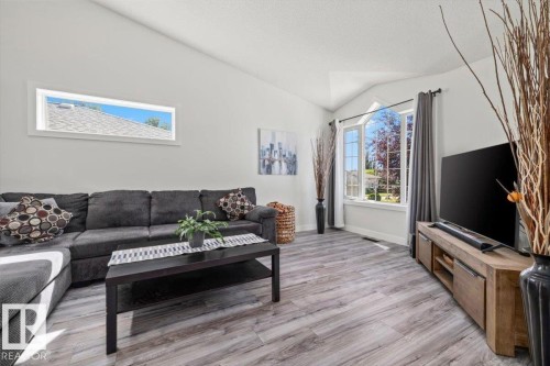 Vaulted ceilings, wood-finish flooring, bow window, horizontal accent window, and white wall finishes - 40 Hampton Place, Stony Plain, AB 