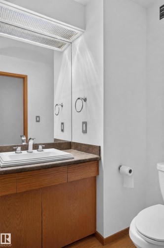 Wood-finish vanity with a drop-in sink, chrome faucet, and integrated brown countertop - 17103 92 Street Nw, Edmonton, AB 
