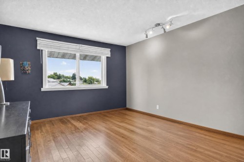 Hardwood flooring, painted walls, track lighting fixture, and a window with blinds - 17103 92 Street Nw, Edmonton, AB 