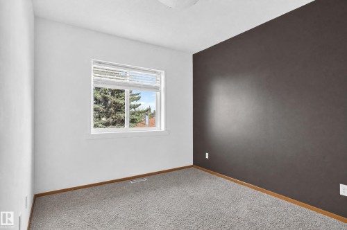 Neutral paint palette with an accent wall, window with blinds, and light-tone carpeting - 17103 92 Street Nw, Edmonton, AB 