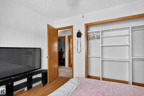 Wood-finish flooring with white walls and a built-in closet system - 17103 92 Street Nw, Edmonton, AB 