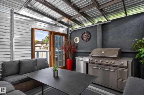 Covered outdoor patio featuring a corrugated metal roof and wood beam supports - 17103 92 Street Nw, Edmonton, AB 