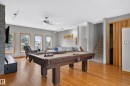 Hardwood-finish flooring, recessed lighting, ceiling fan, natural light from multiple windows, and a built-in window bench - 17103 92 Street Nw, Edmonton, AB 