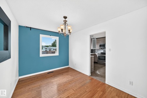 Hardwood flooring, chandelier lighting, and a defined accent wall - 11007 37 Avenue Nw, Edmonton, AB 