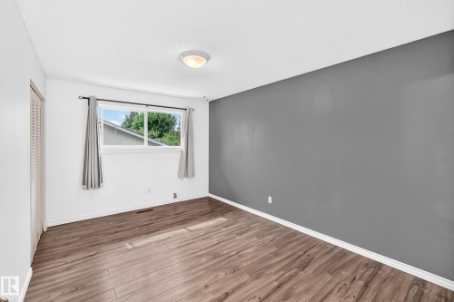 Wood-finish flooring, white trim, and a window with a white frame - 11007 37 Avenue Nw, Edmonton, AB 