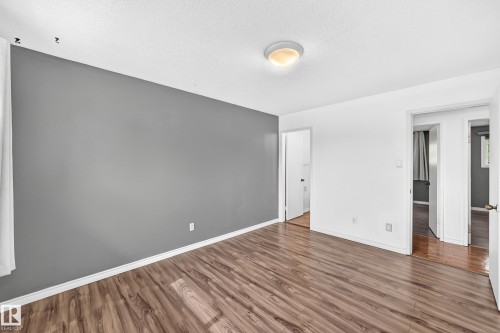 Wood-finish flooring throughout, complemented by a prominent accent wall - 11007 37 Avenue Nw, Edmonton, AB 