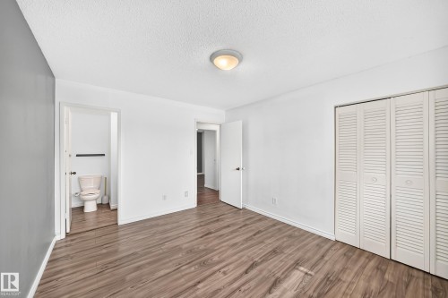 Wood-finish flooring with white walls and a contrasting gray accent wall - 11007 37 Avenue Nw, Edmonton, AB 