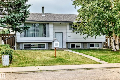 Split-level residence featuring a gray shingle roof, white siding exterior, and a concrete foundation - 11007 37 Avenue Nw, Edmonton, AB 