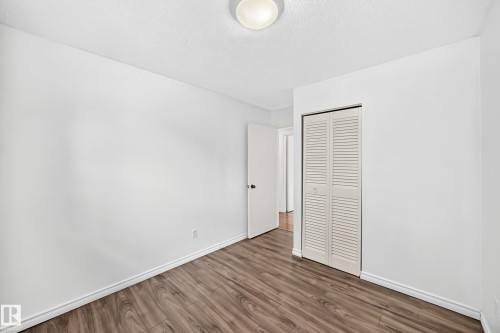 Wood-finish flooring, white walls, louvered closet doors, and flush-mount ceiling lighting - 11007 37 Avenue Nw, Edmonton, AB 