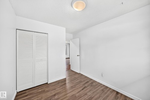 White walls, flush-mount ceiling light, white louvered bifold closet doors, wood-finish flooring - 11007 37 Avenue Nw, Edmonton, AB 