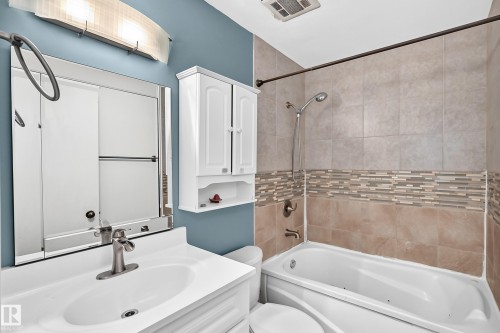 Vanity with an integrated sink, brushed nickel faucet, and mirrored medicine cabinet - 11007 37 Avenue Nw, Edmonton, AB 