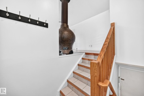 Staircase featuring wood railing and tile treads - 11007 37 Avenue Nw, Edmonton, AB 