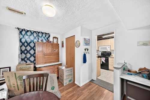 Wood-finish flooring throughout, with a built-in closet featuring a bi-fold door - 11007 37 Avenue Nw, Edmonton, AB 