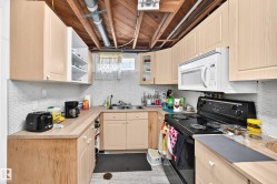Kitchen featuring wood-finish cabinetry, wood-finish countertops, stainless steel double basin sink, and a tiled backsplash - 