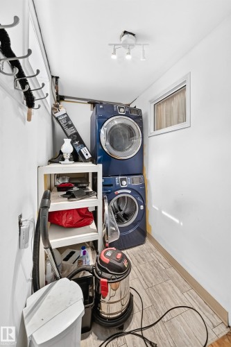 Stacked laundry appliances, overhead track lighting, wood-finish flooring, and a single window - 11007 37 Avenue Nw, Edmonton, AB 