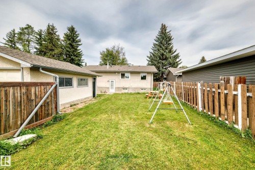 Expansive lawn area with mature trees, bordered by a wood fence - 11007 37 Avenue Nw, Edmonton, AB 