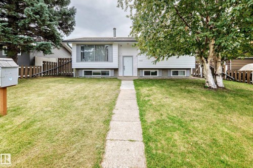 Front exterior featuring white siding, a prominent picture window, and a concrete walkway - 11007 37 Avenue Nw, Edmonton, AB 