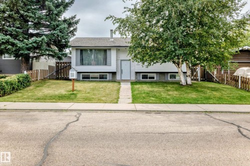 White exterior siding, front lawn, mature trees, and a picket fence - 11007 37 Avenue Nw, Edmonton, AB 