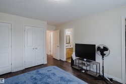 Dark wood-finish flooring, white painted walls, and white paneled doors - 