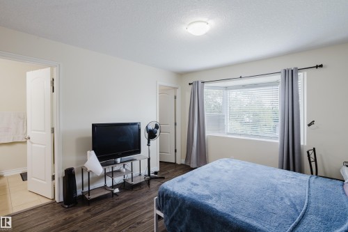 Bay window with blinds, wood-finish flooring, white trim, and a flush mount ceiling light - 10332 161 Street Nw, Edmonton, AB 