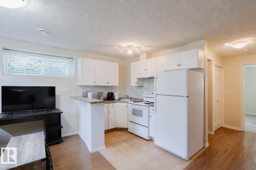 Compact kitchen featuring white cabinetry and appliances - 10332 161 Street Nw, Edmonton, AB 