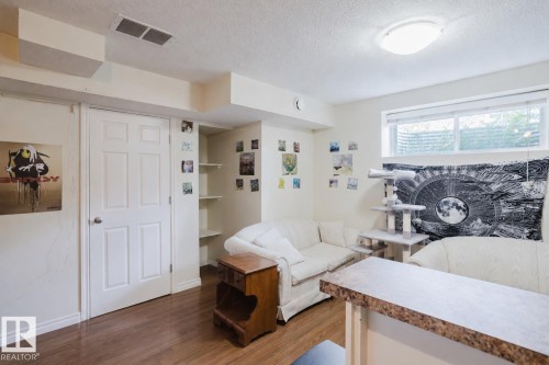 Wood-finish flooring, built-in shelving, white six-panel interior door, recessed wall opening, and a built-in counter surface with a textured finish - 10332 161 Street Nw, Edmonton, AB 