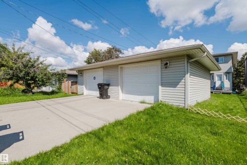 Two-car garage with light gray siding and white overhead doors - 10332 161 Street Nw, Edmonton, AB 