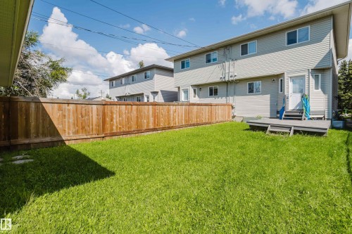 Expansive grass yard with a wood privacy fence and a ground-level deck - 10332 161 Street Nw, Edmonton, AB 