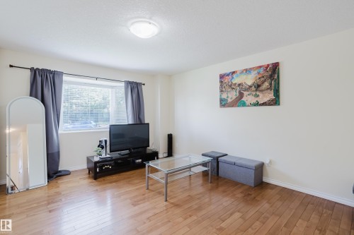 Wood-finish flooring, white walls, and a large window with blinds - 10332 161 Street Nw, Edmonton, AB 