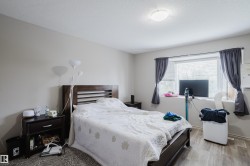 Neutral wall paint, wood-finish flooring, ceiling-mounted light fixture, window with blinds, and dark window treatments - 