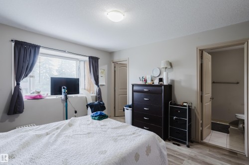 Spacious room featuring a large window, light-toned walls, and wood-finish flooring - 10334 161 Street Nw, Edmonton, AB 