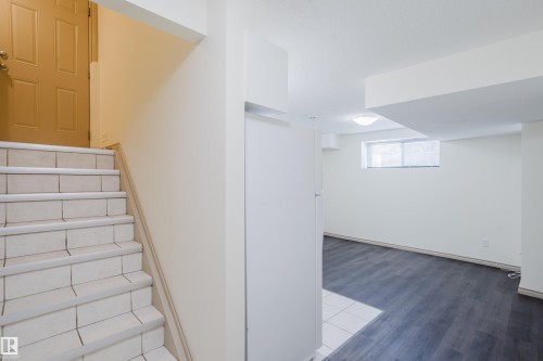 Tile staircase with a wood-finish door - 10334 161 Street Nw, Edmonton, AB 