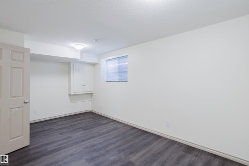 Wood-finish flooring with white walls and a built-in cabinet - 10334 161 Street Nw, Edmonton, AB 