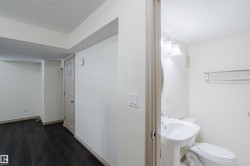 Pedestal sink, wall-mounted vanity lighting, and chrome towel bar in the bathroom - 