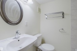 Pedestal sink with chrome faucet, oval framed mirror, and chrome towel rack - 