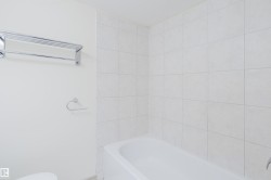 Integrated bathtub with white tile surround and chrome fixtures - 