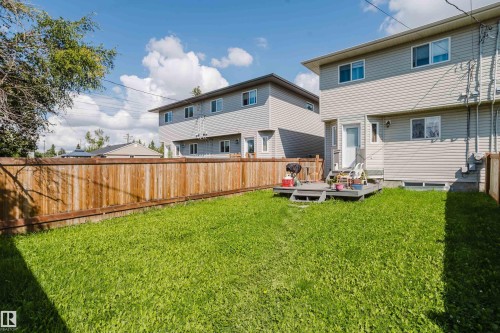 Expansive grassy yard with a wood privacy fence and a ground-level deck - 10334 161 Street Nw, Edmonton, AB 