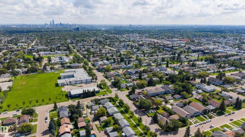 Expansive urban landscape featuring a distant skyline, residential neighborhoods with mature trees, and a visible commercial area - 10334 161 Street Nw, Edmonton, AB 