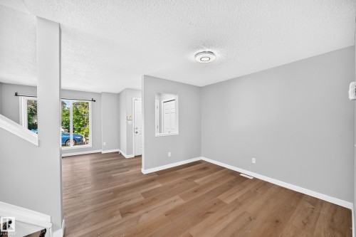 Open concept living space featuring wood-finish flooring and light gray painted walls - 203 84 Street Sw, Edmonton, AB - Indoor Photo Showing Other Room