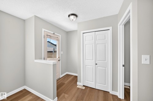Entryway featuring wood-finish flooring, light gray wall paint, and white trim - 203 84 Street Sw, Edmonton, AB - Indoor Photo Showing Other Room